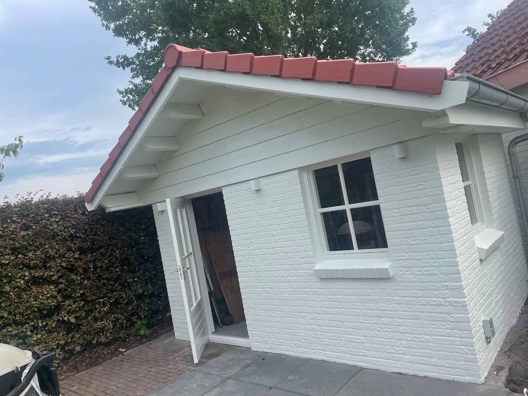 Tuinhuis met wit geschilderde gevel, kozijnen en deuren